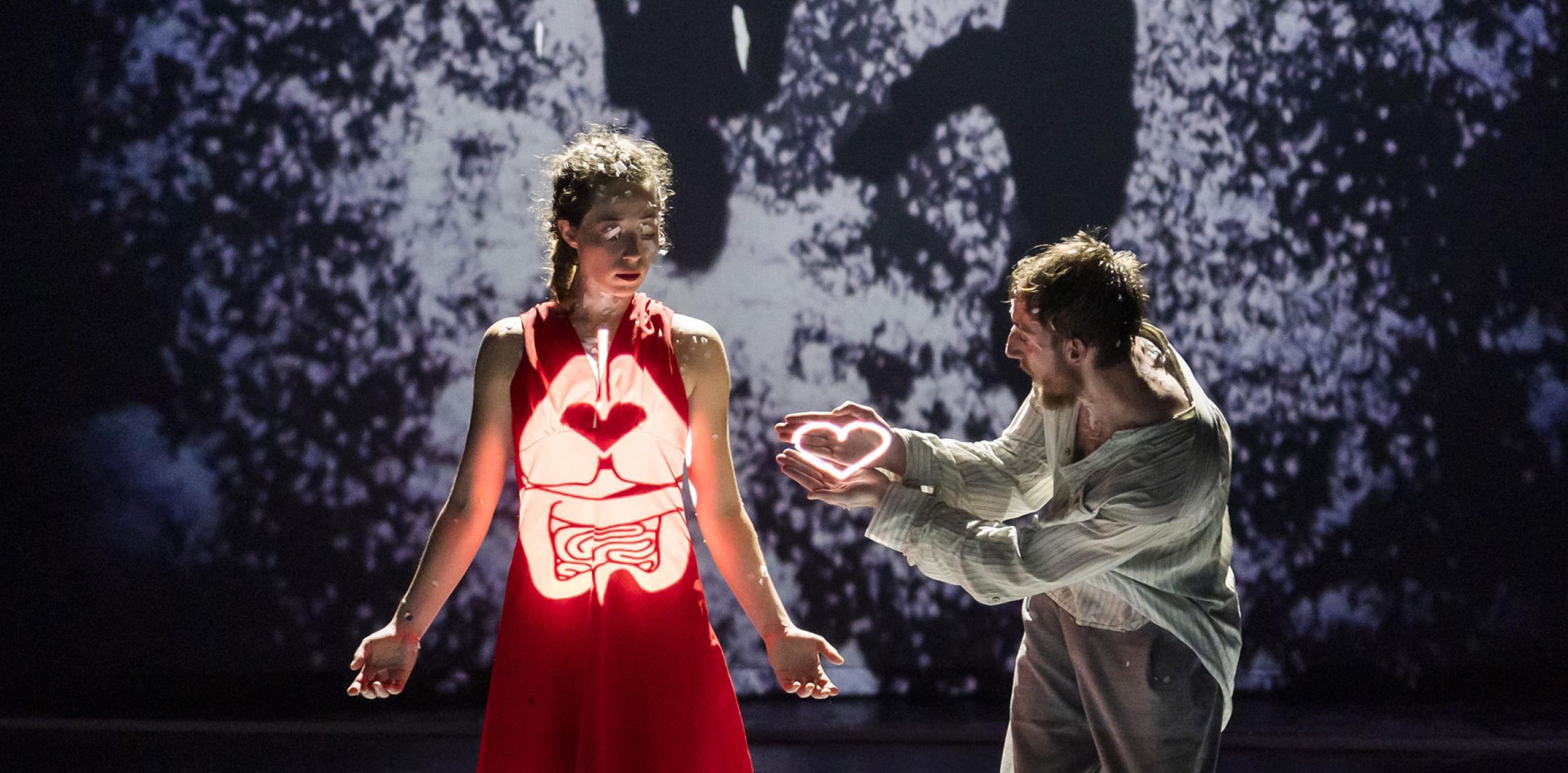 Two dancers interacting with light projections