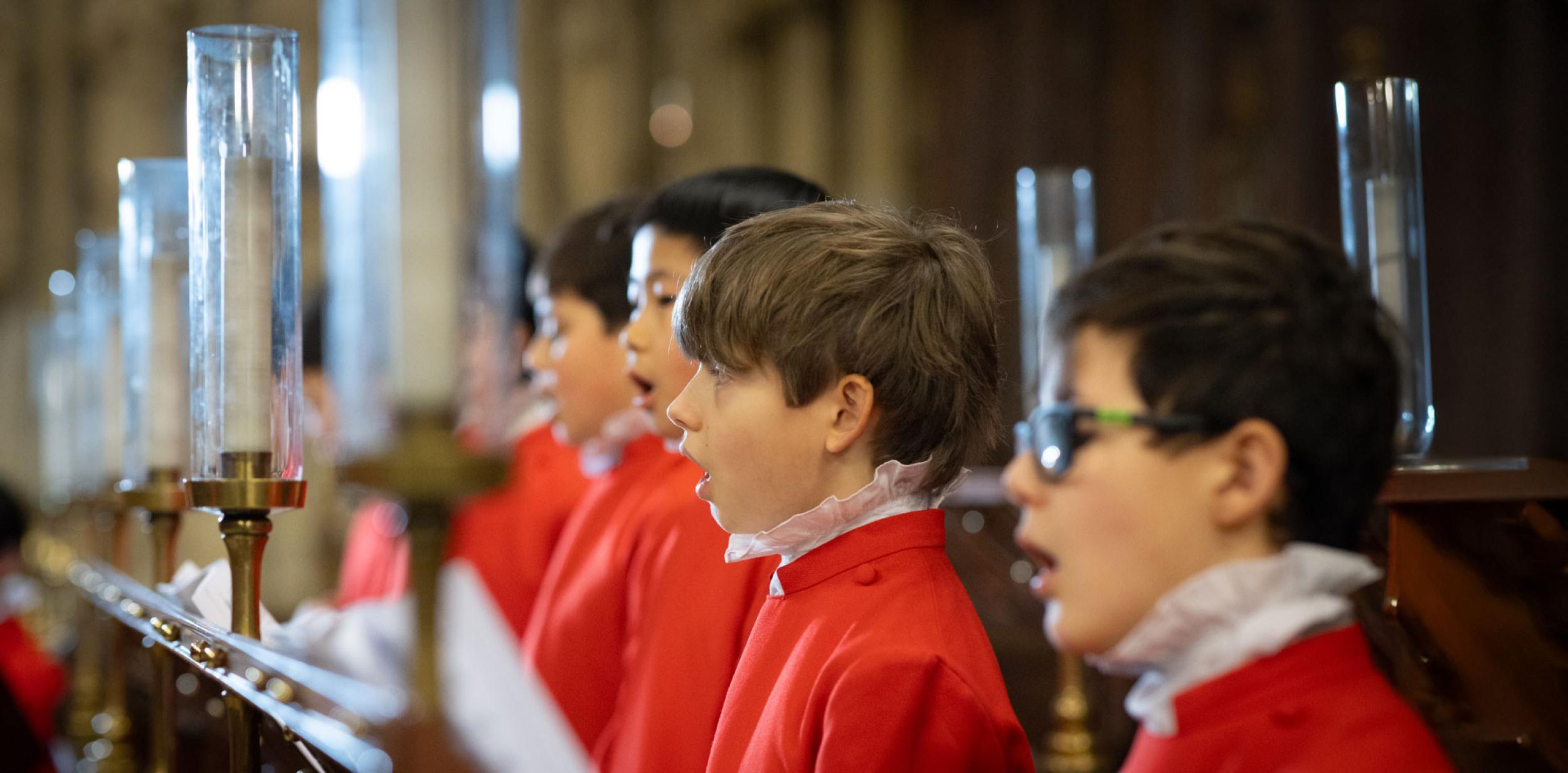 Choir boys singing in their red robes