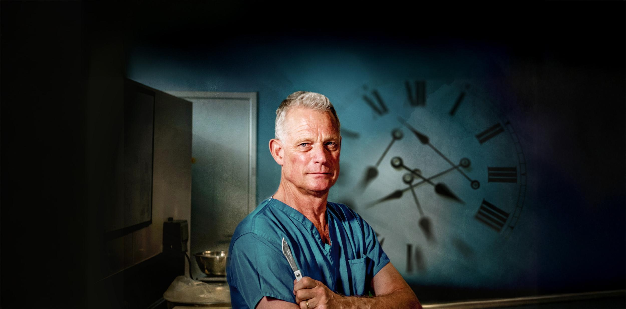 Richard Shepherd in scrubs looking at the camera with a scalpel in his hand