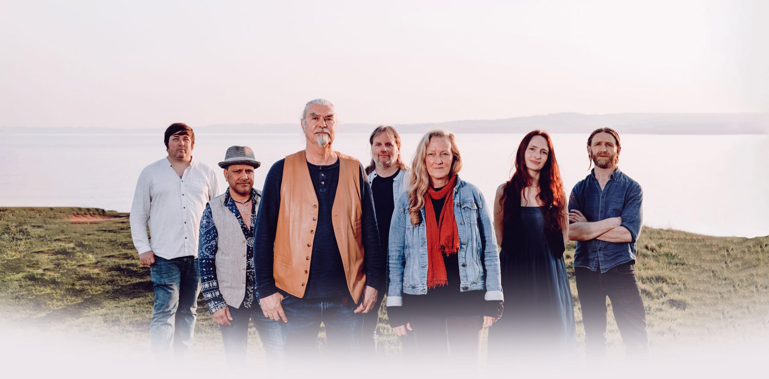 Saltlines band on the edge of a cliff with the sea behind them